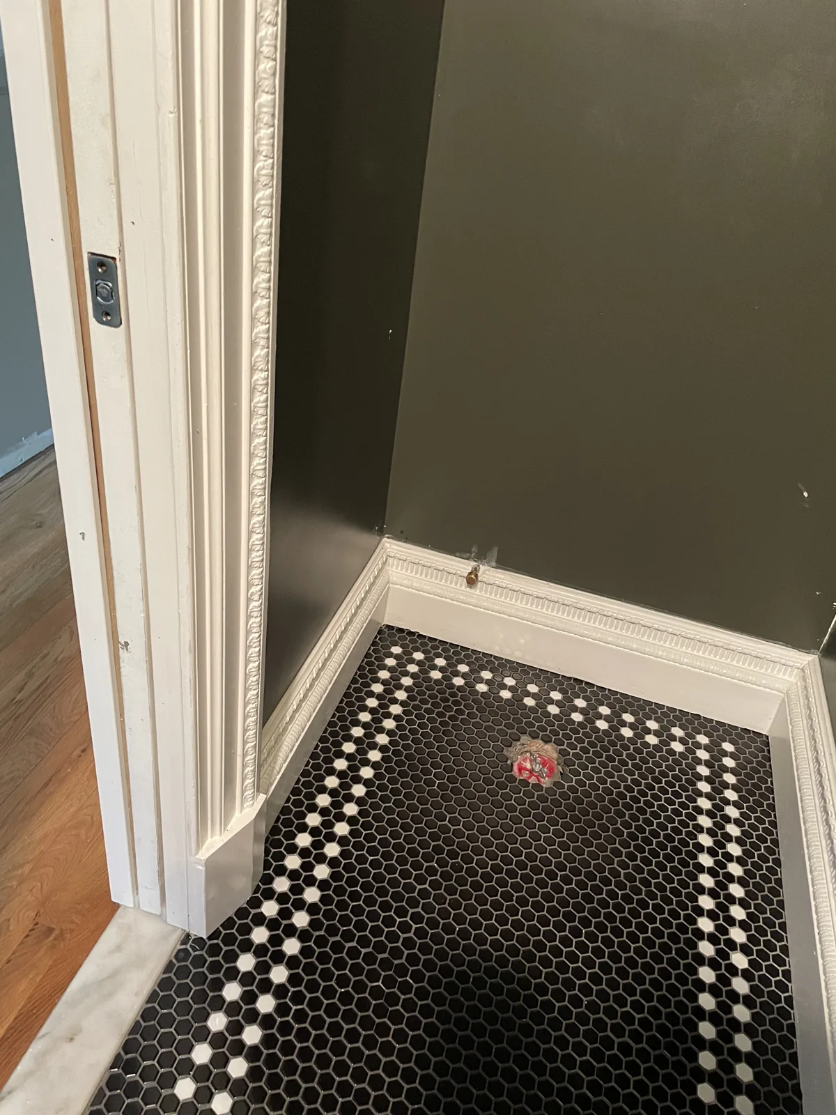 Black and white mosaic floor detail during the half bath transformation